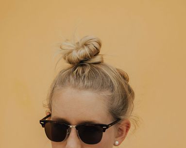 Photo of a woman wearing sunglasses with her hair on bun